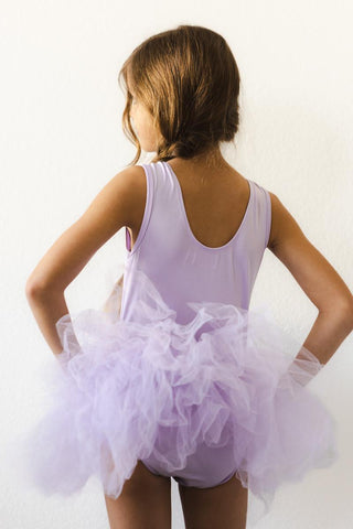 Young girl in a purple ballet outfit with a white background