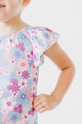 Child wearing a floral leotard with a white background
