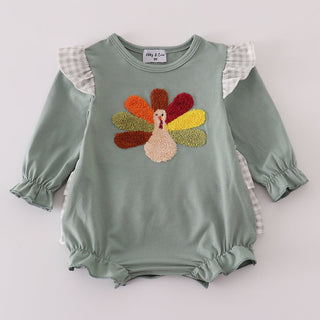 Green baby romper with colorful turkey design on a white background