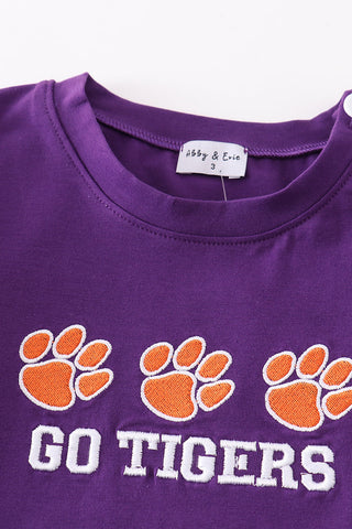 Close-up of orange tiger paw embroidery on purple boy top