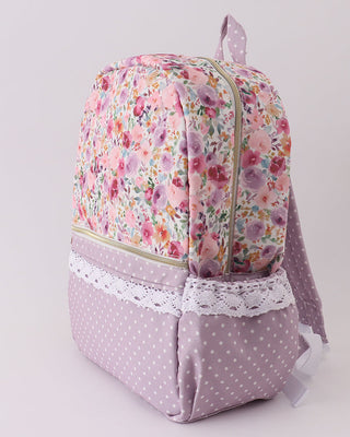 Floral-patterned backpack with pink polka dot accents on a light gray background