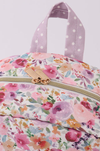 Floral-patterned bag with a polka dot handle on a light purple background