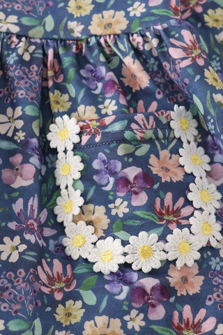 Floral patterned fabric with a border of white flowers on a blue background