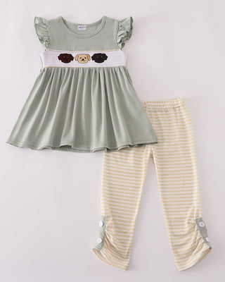 Children's outfit with green top and beige striped pants on a white background