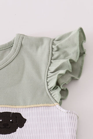 Light green ruffled top with a white ribbed base and black dog illustration on a light gray background