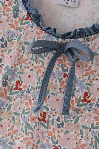 Floral-patterned fabric with a blue ribbon tied in the center