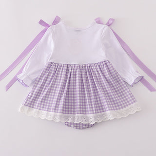 Baby romper with a white long-sleeve top and purple checkered skirt on a light gray background.