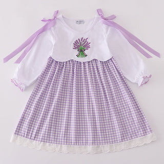 Children's dress with white top and purple checkered skirt on a light gray background