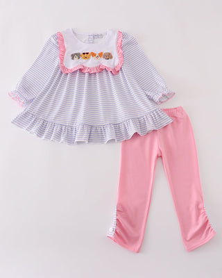 Children's outfit with striped top and pink pants on a light gray background
