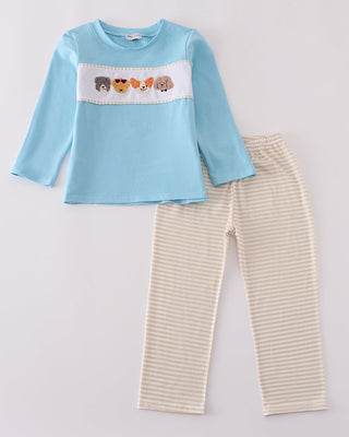 Children's outfit with blue top and beige striped pants on a light gray background