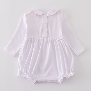 White baby romper with long sleeves on a light gray background