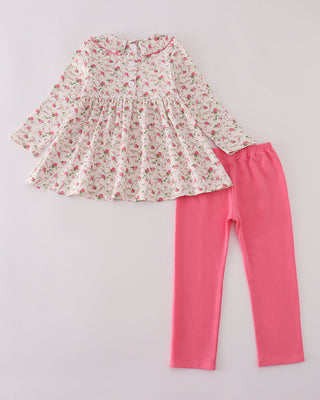 Floral top and pink leggings set on a light gray background