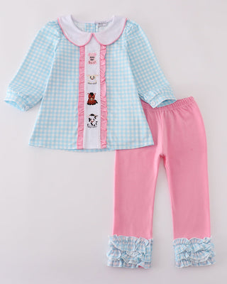 Children's outfit with checkered shirt and pink pants on a light gray background