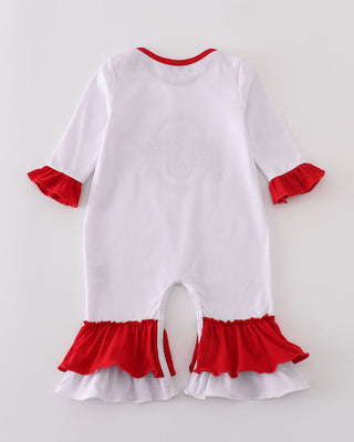 White baby romper with red ruffles on a light gray background