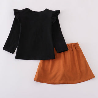 Black top with ruffled sleeves and orange skirt on a white background
