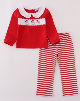 Red top with white lace collar and red and white striped pants on a light gray background