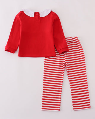 Red top and red and white striped pants on a light gray background