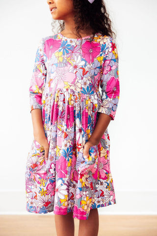 Child wearing a colorful floral dress on a white background