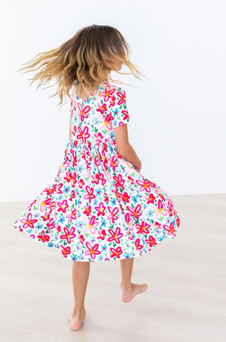 Child wearing a colorful floral dress on a white background