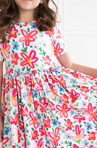 Child wearing a colorful floral dress on a white background