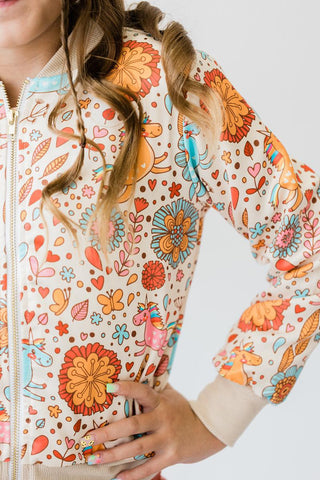 Person wearing a colorful patterned jacket with floral and animal designs.