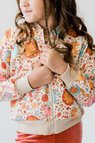 Child wearing a colorful floral-patterned jacket with a white background