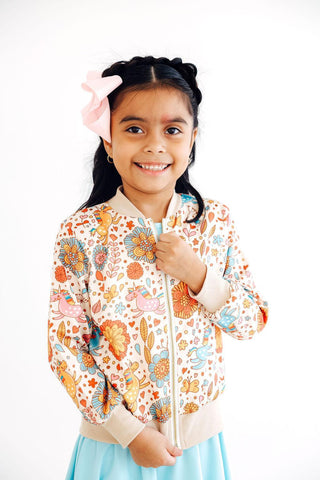 Young girl wearing a colorful floral jacket with a white background
