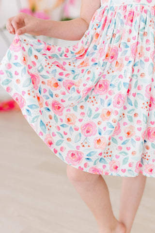 Floral dress with pink flowers and green leaves on a light background