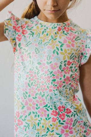 Child wearing a floral dress with a plain background