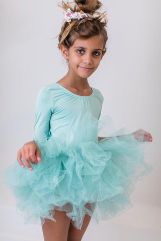 Young girl wearing a light blue dress with a white background