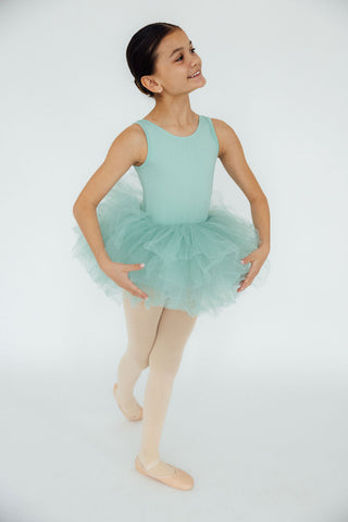 Young girl in a mint green ballet outfit on a white background