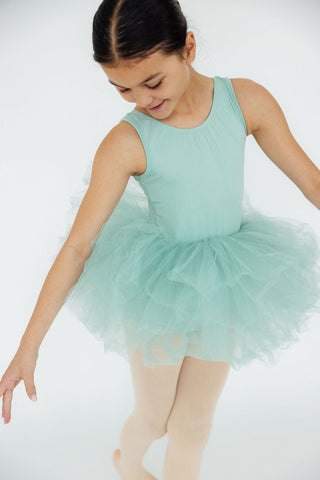 Young girl in a mint green ballet dress posing against a white background