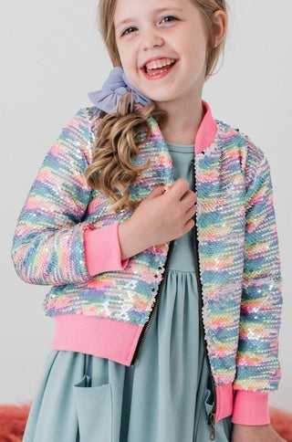 Young girl wearing a colorful striped jacket with pink accents on a plain background