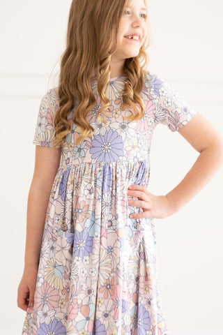 Young girl wearing a floral dress on a white background