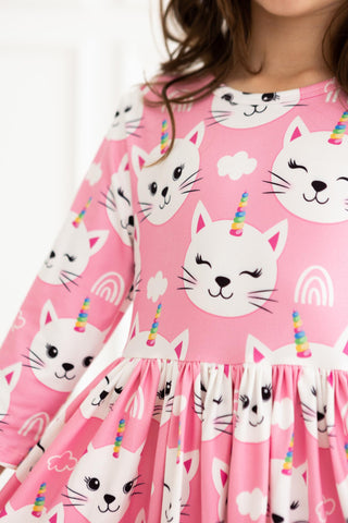 Pink dress with cat and unicorn print worn by a person