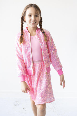 Young girl wearing a pink sequin outfit on a white background