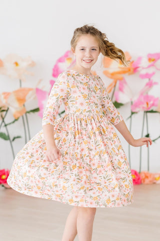 Young girl wearing a floral dress with a decorative background