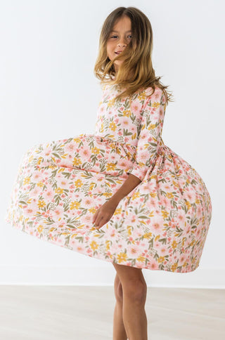 Girl wearing a floral dress against a white background
