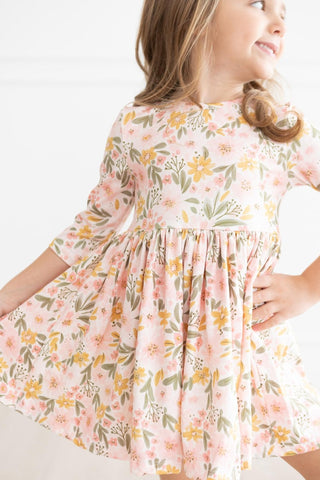 Young girl wearing a floral dress with a white background