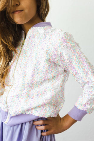 Child wearing a sequined jacket with a plain background
