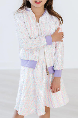 Child wearing a white skirt with purple accents on a white background