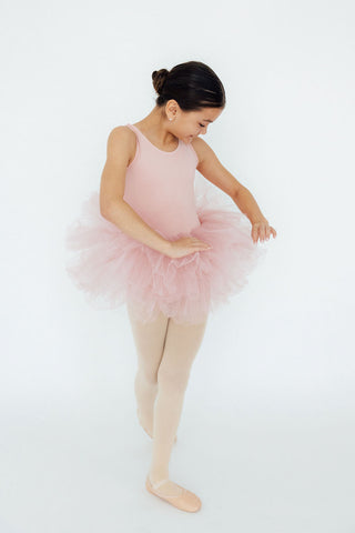 Ballerina in a pink tutu and beige tights on a white background