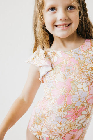 Young girl wearing a floral dress with a white background