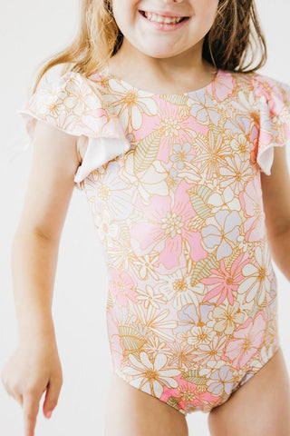 Child wearing a floral leotard with ruffled sleeves on a white background