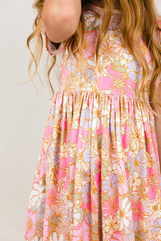 Floral dress with pink, orange, and blue flowers on a plain background